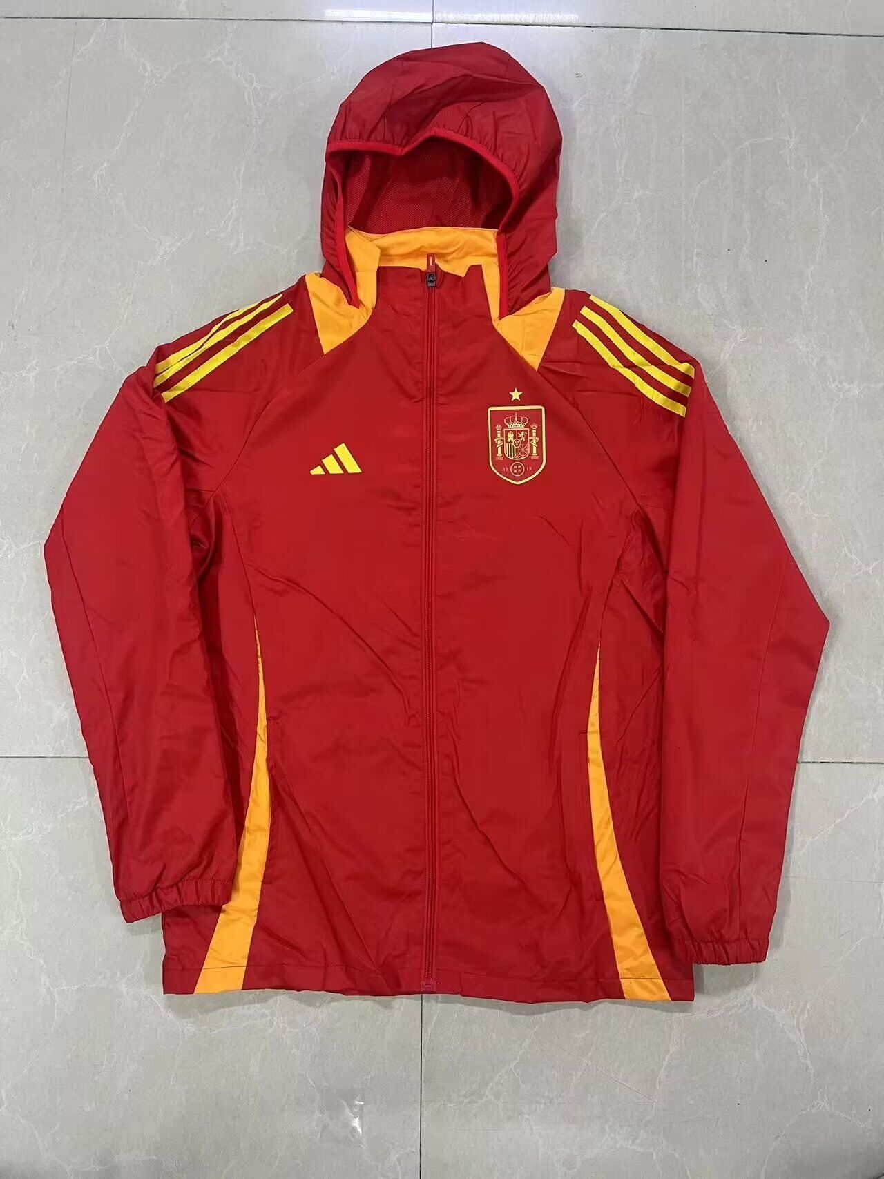 Chaqueta cortavientos con gorro España amarilla (solo tallas S-XXL)