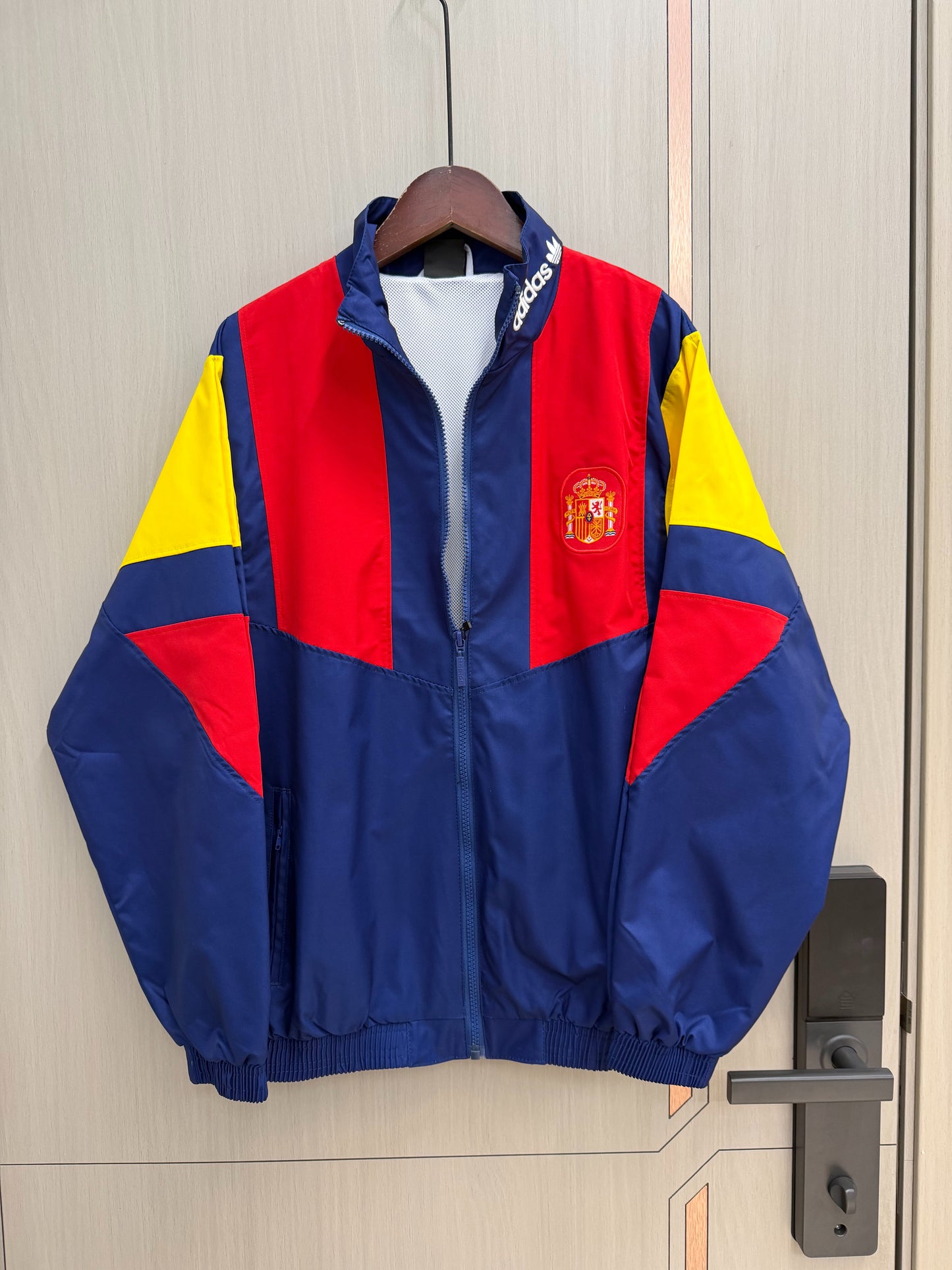 Chaqueta cortavientos España 2026 azul con rojo amarillo (tallas S-XXL)