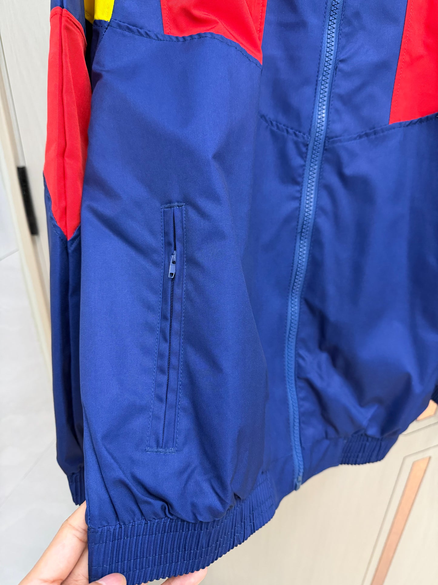 Chaqueta cortavientos España 2026 azul con rojo amarillo (tallas S-XXL)