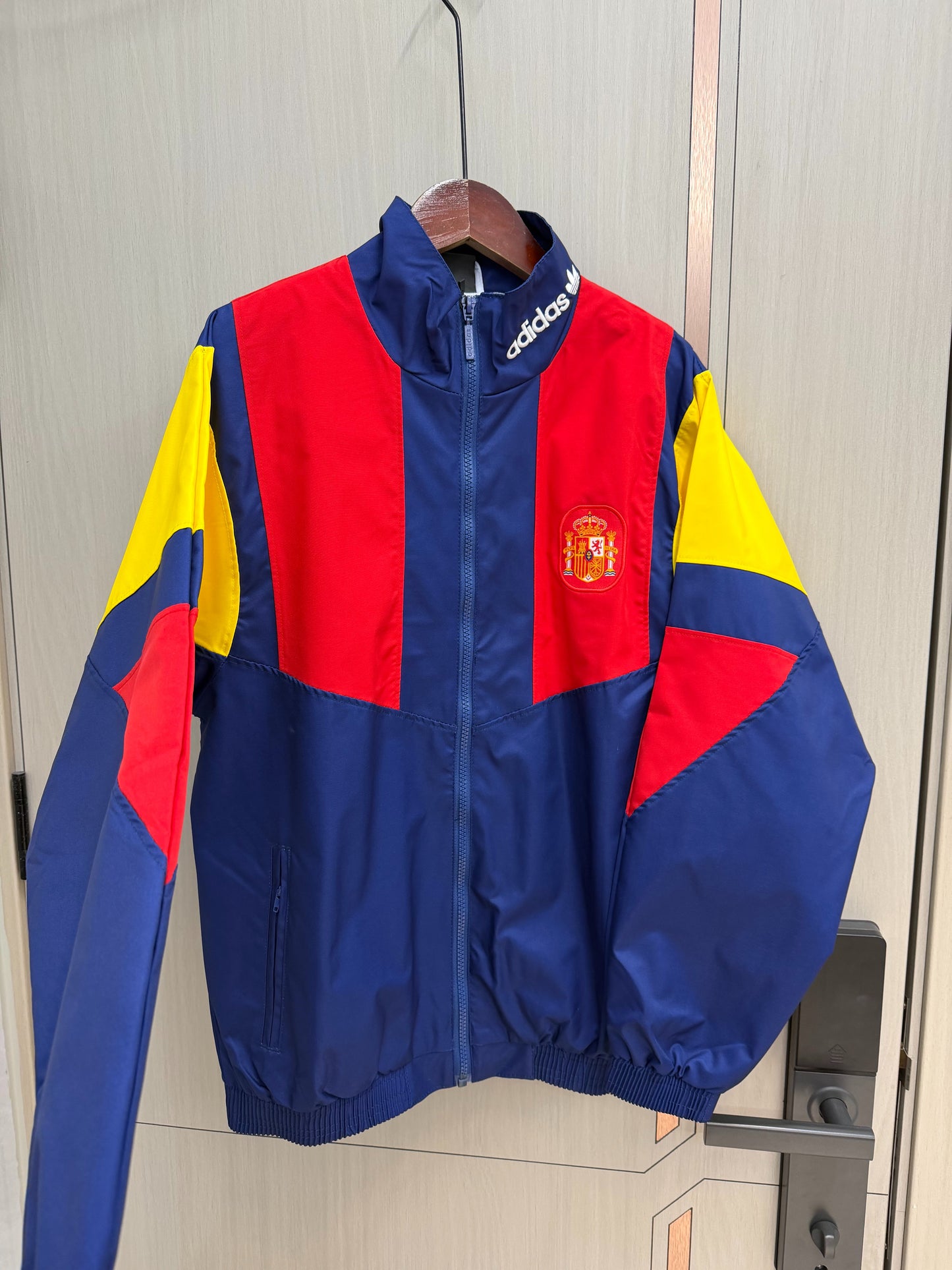 Chaqueta cortavientos España 2026 azul con rojo amarillo (tallas S-XXL)