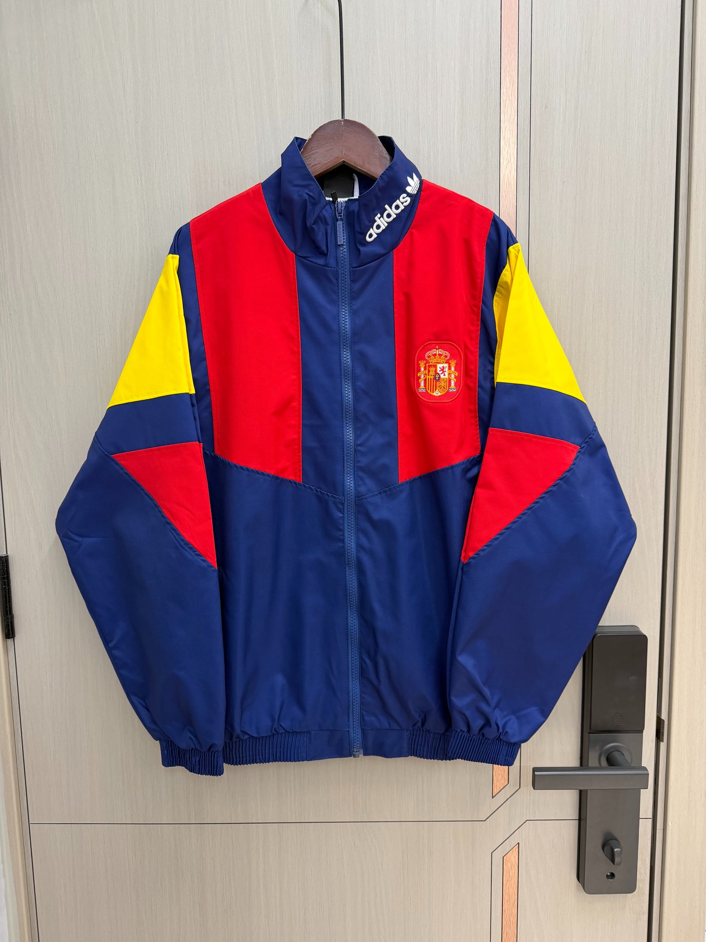 Chaqueta cortavientos España 2026 azul con rojo amarillo (tallas S-XXL)